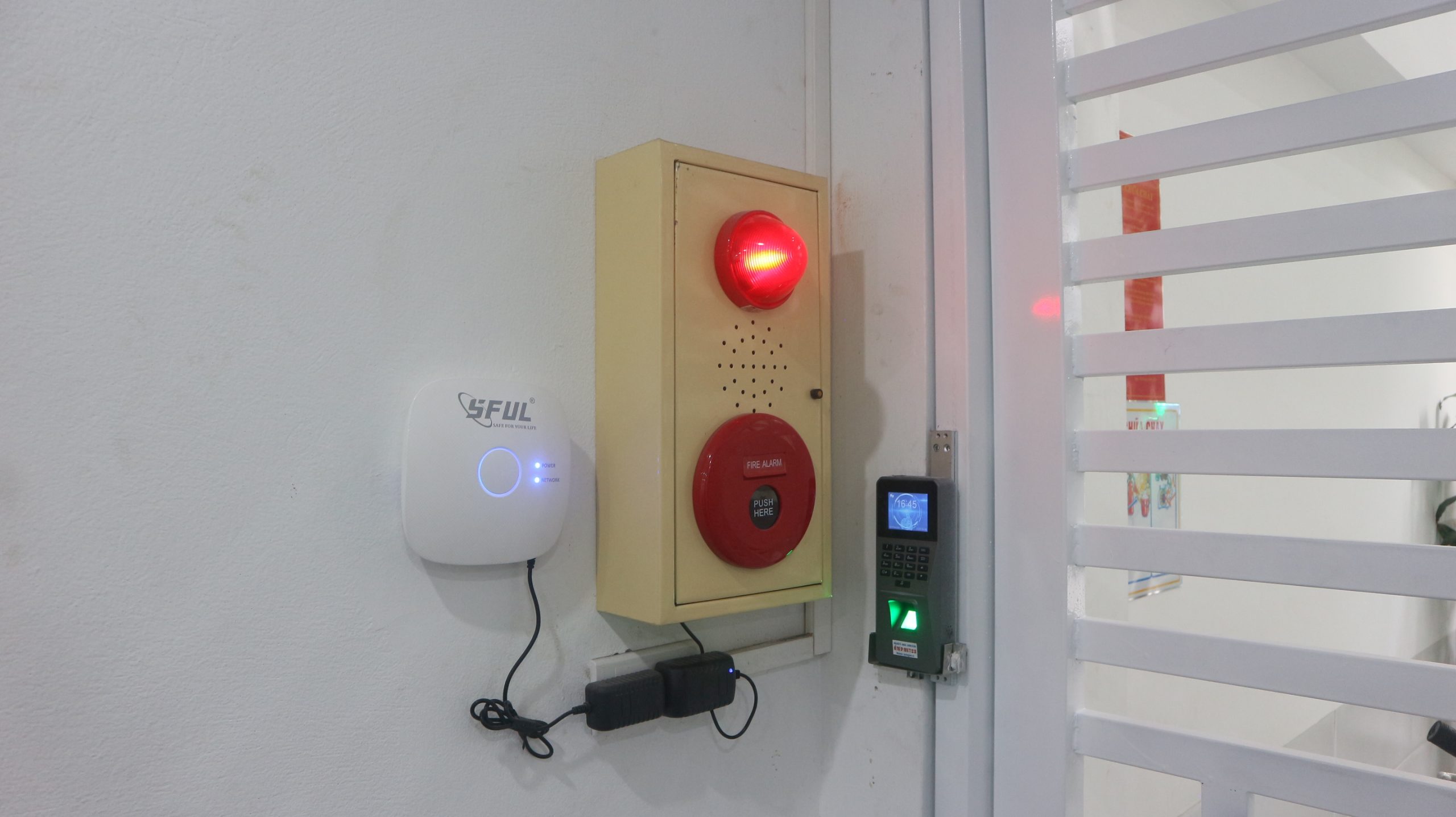 Lắp đặt thực tế chuông báo cháy kết hợp hệ thống kiểm soát cửa và máy chấm công tại lối ra vào văn phòng.